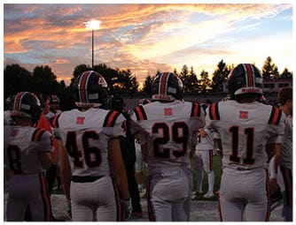 A group of football players on a field. Description generated by AI