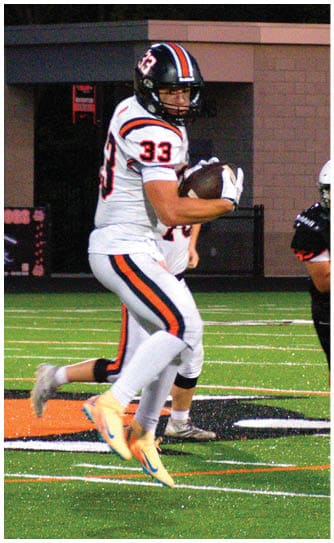 A football player catching a ball. Description generated by AI