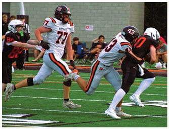 A group of football players on a field. Description generated by AI