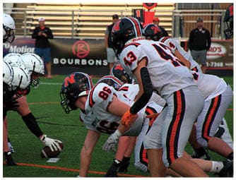 A group of football players on a field. Description generated by AI