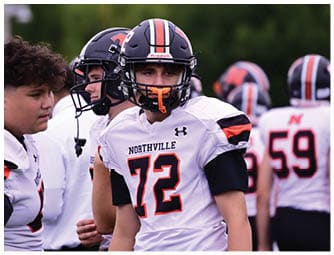 A group of football players on a field. Description generated by AI