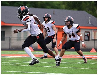 A group of football players on a field. Description generated by AI