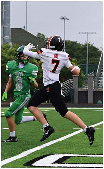 A football player catching a ball. Description generated by AI