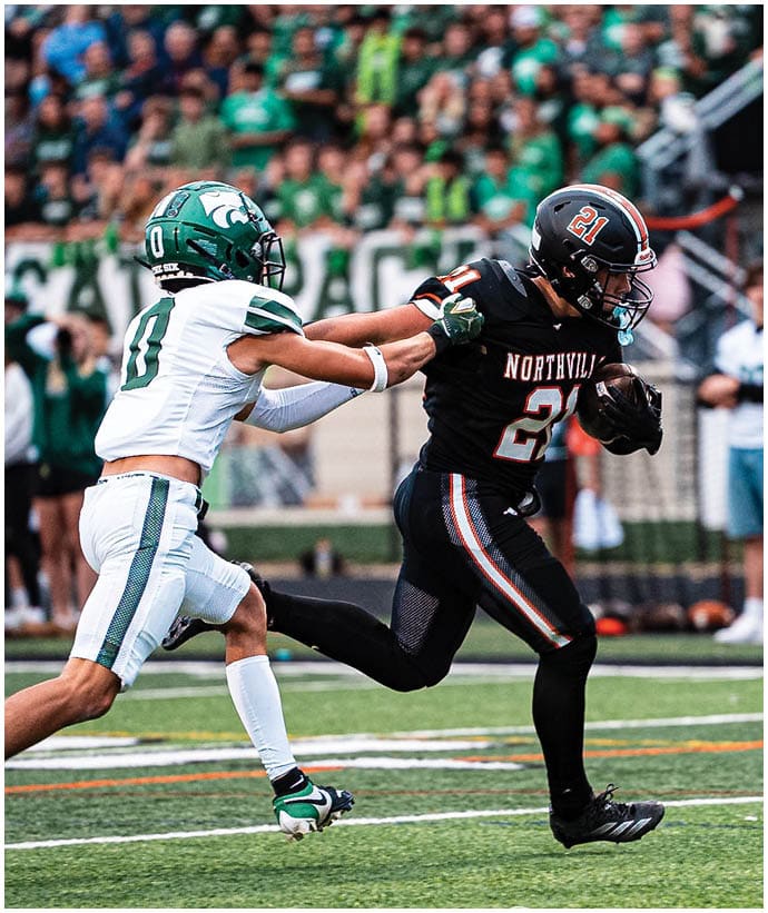 A group of football players wearing black and white uniforms. Description generated by AI