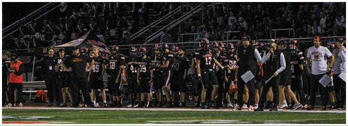 A group of football players on a field. Description generated by AI