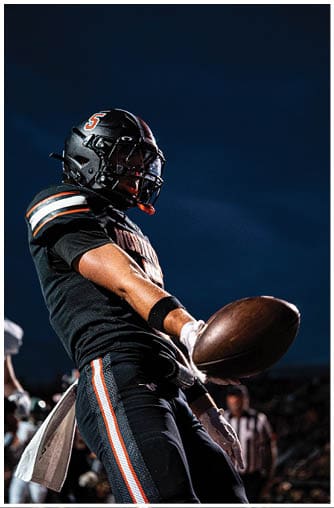 A football player running on the field. Description generated by AI