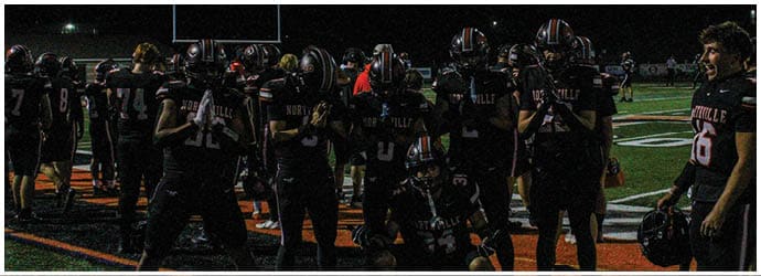 A group of football players on a field. Description generated by AI
