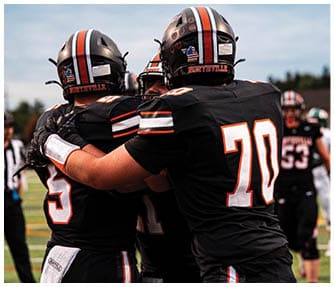 A group of football players wearing black and white uniforms. Description generated by AI