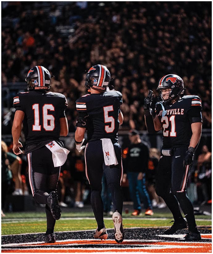 A group of football players wearing black and white uniforms. Description generated by AI
