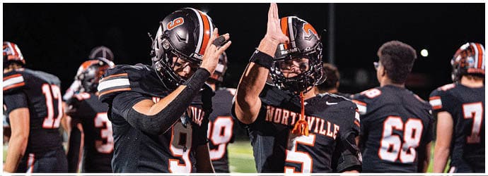 A group of football players on a field. Description generated by AI