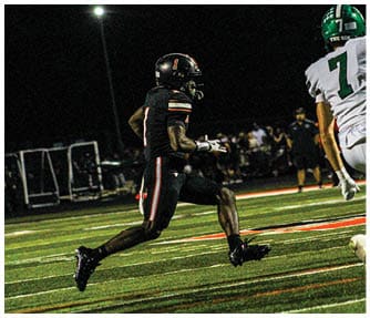 A group of football players wearing black and white uniforms. Description generated by AI