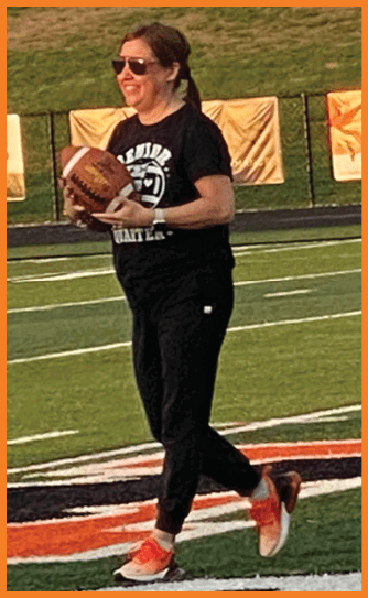 A football player catching a ball. Description generated by AI