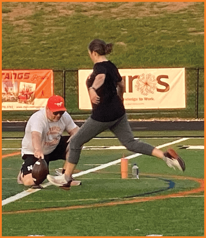 Three football players in blue and white uniforms running on a field. Description generated by AI