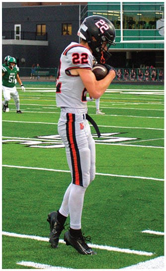 A football player catching a ball. Description generated by AI