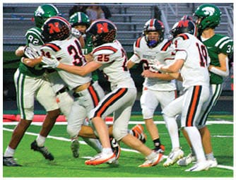 A group of football players on a field. Description generated by AI