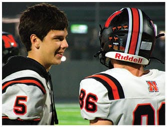 A group of football players on a field. Description generated by AI