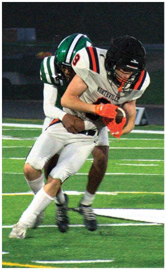A football player catching a ball. Description generated by AI