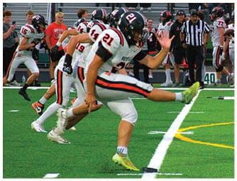 A group of football players on a field. Description generated by AI