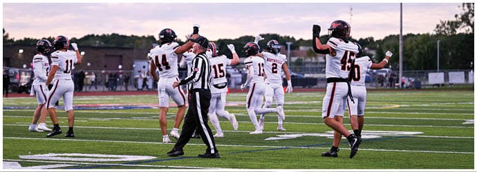 A group of football players on a field. Description generated by AI