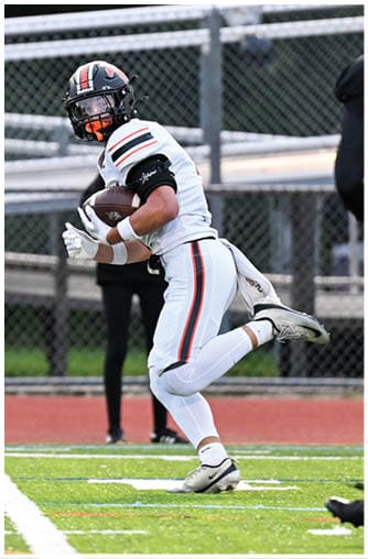 A football player running on the field. Description generated by AI