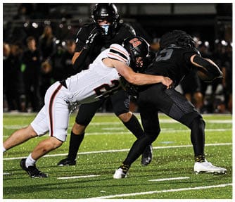A group of football players wearing black and white uniforms. Description generated by AI