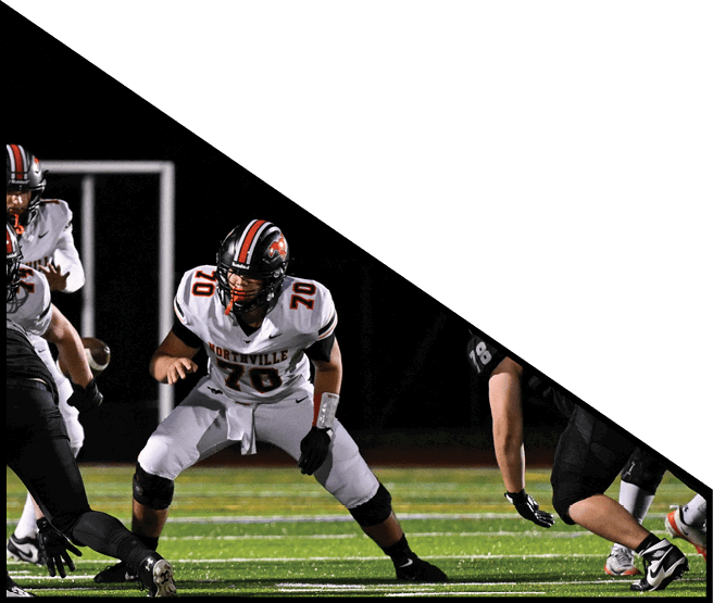 A group of football players kneeling on the field, some with their hands on their heads. AI generated content