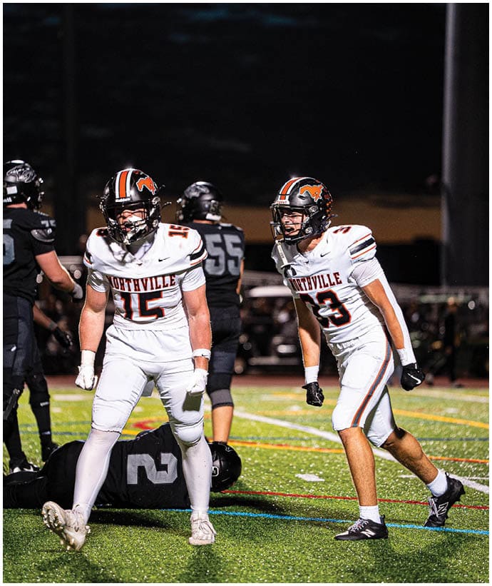 A group of football players wearing black and white uniforms. Description generated by AI