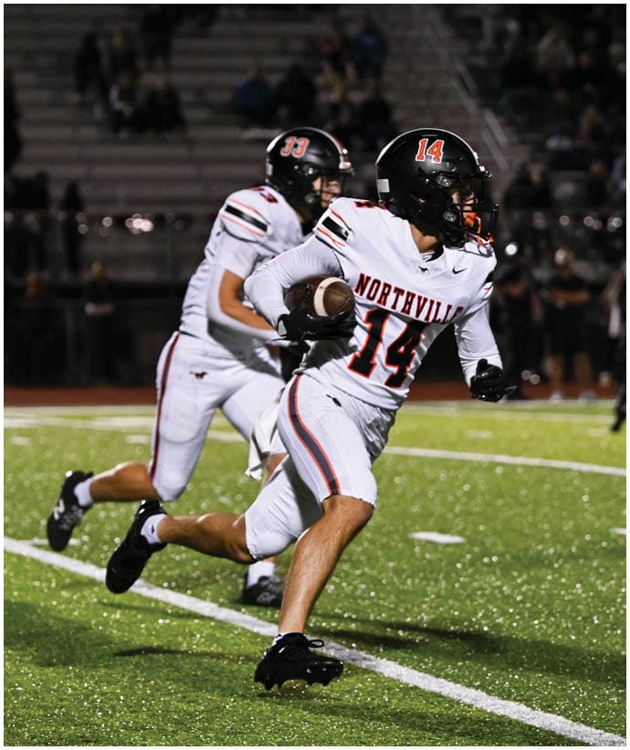 A group of football players wearing black and white uniforms. Description generated by AI