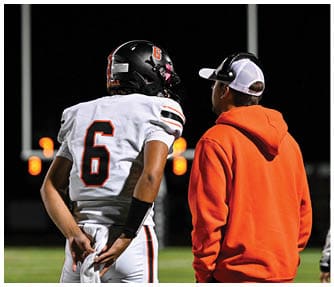 A group of football players wearing black and white uniforms. Description generated by AI
