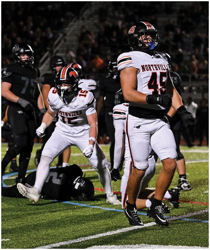 A group of football players wearing black and white uniforms. Description generated by AI