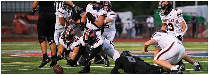 A group of football players on a field. Description generated by AI