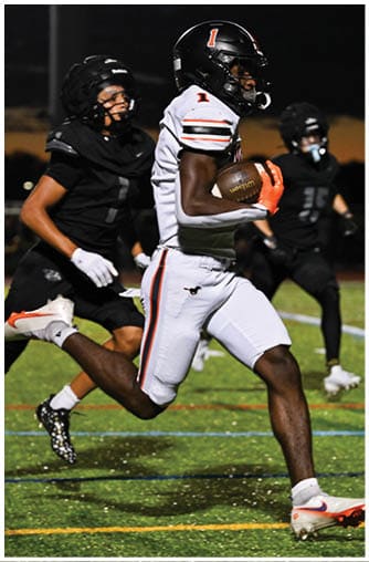A football player running on the field. Description generated by AI