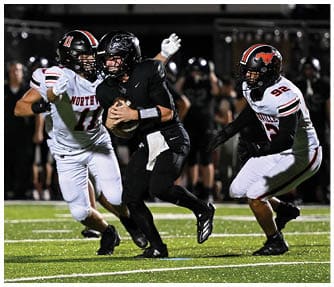 A group of football players wearing black and white uniforms. Description generated by AI