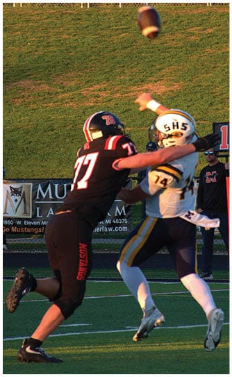 A football player catching a ball. Description generated by AI
