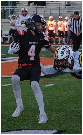 A football player catching a ball. Description generated by AI