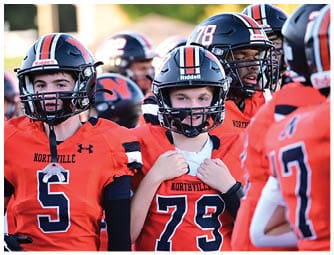 A group of football players on a field. Description generated by AI