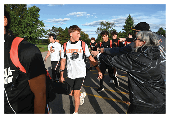 A group of football players wearing headphones and smiling. AI generated content