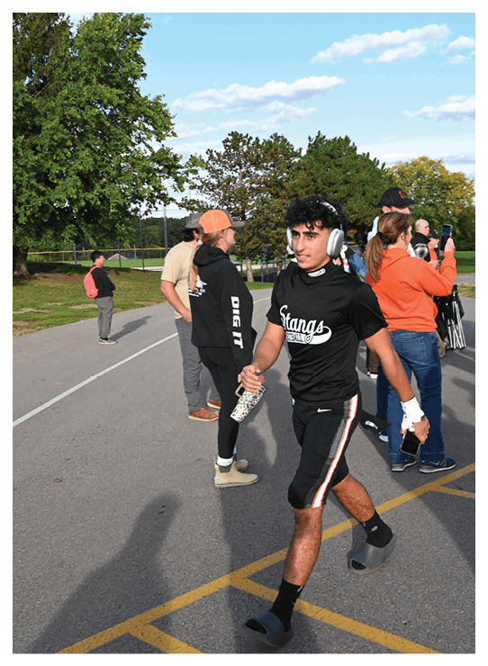 A football player wearing a helmet and white uniform is holding his helmet above his head. AI generated content