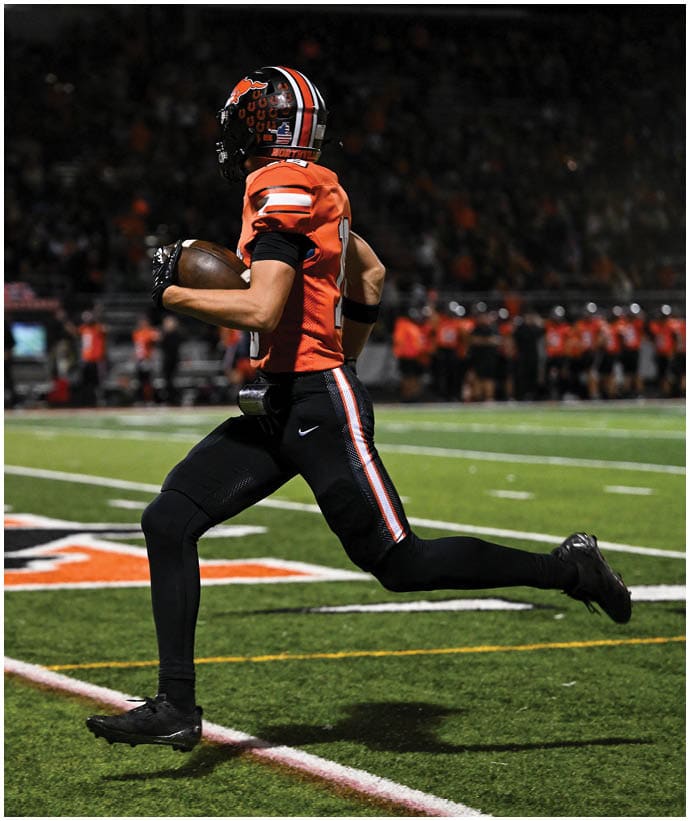 A group of football players wearing black and white uniforms. Description generated by AI