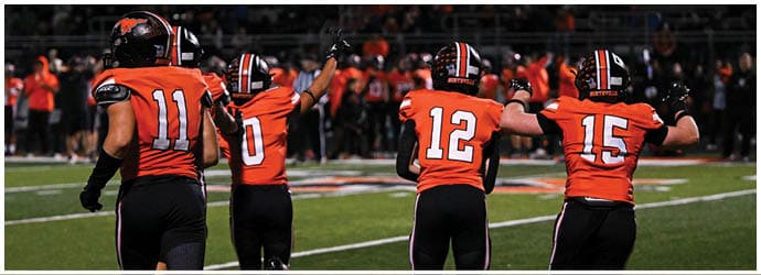 A group of football players on a field. Description generated by AI