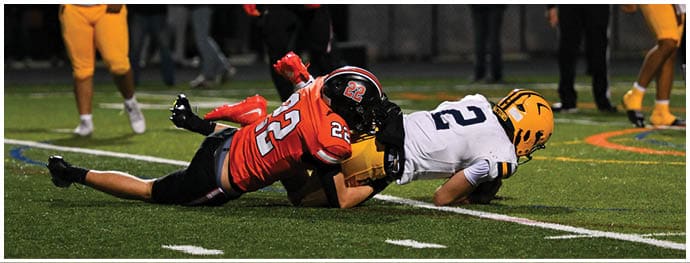 A football player is sliding on the ground. Description generated by AI