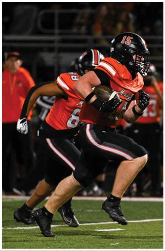 A football player running on the field. Description generated by AI