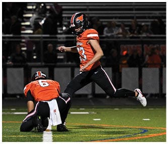 A group of football players wearing black and white uniforms. Description generated by AI