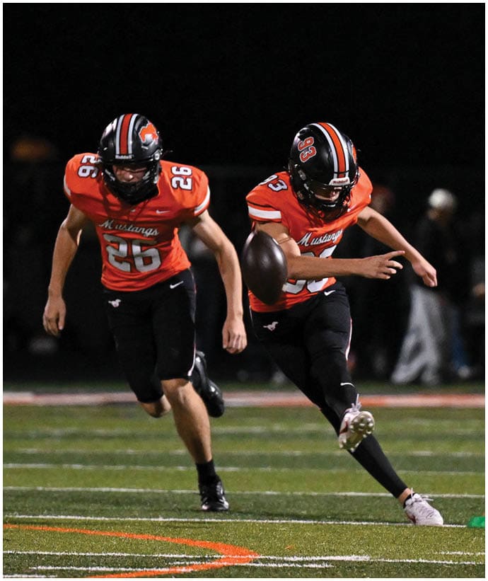 A group of football players wearing black and white uniforms. Description generated by AI