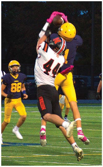 A football player catching a ball. Description generated by AI