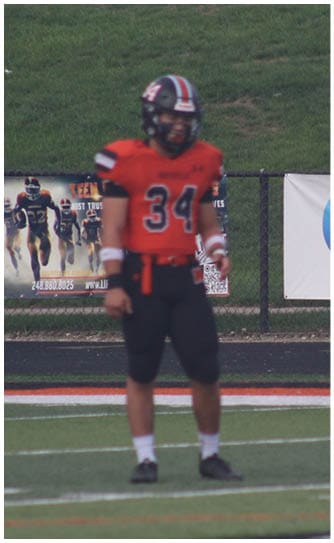 A football player catching a ball. Description generated by AI