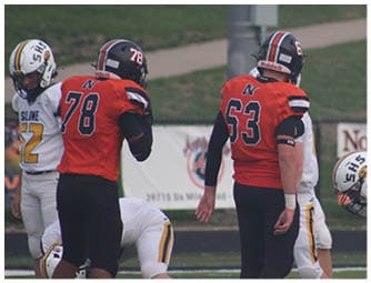 A group of football players on a field. Description generated by AI