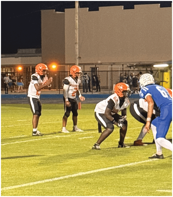 A group of football players wearing black and white uniforms. Description generated by AI