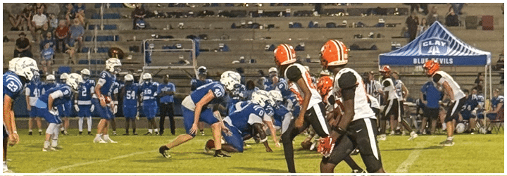 A group of football players on a field. Description generated by AI
