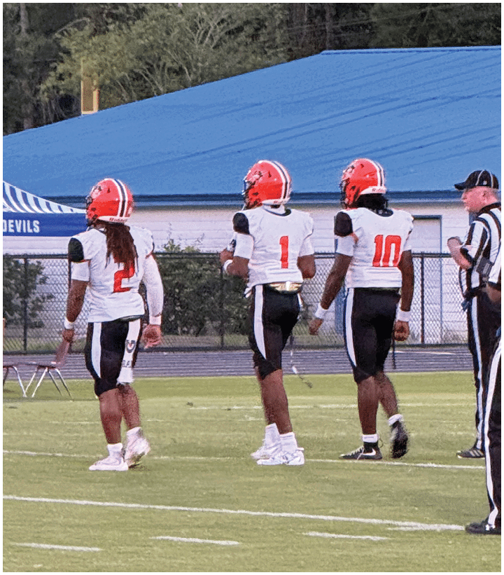 A group of football players wearing black and white uniforms. Description generated by AI